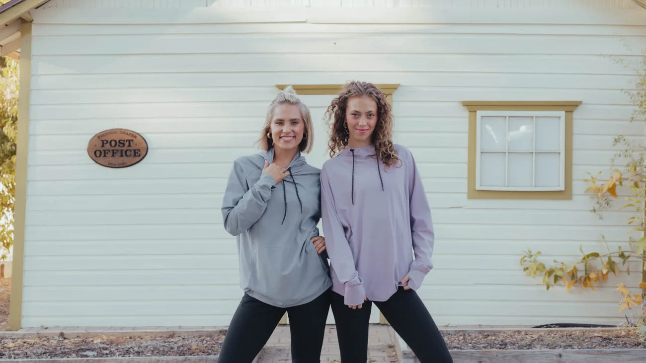 Two women wearing grey and lavender Lift Threadz hoodies outside